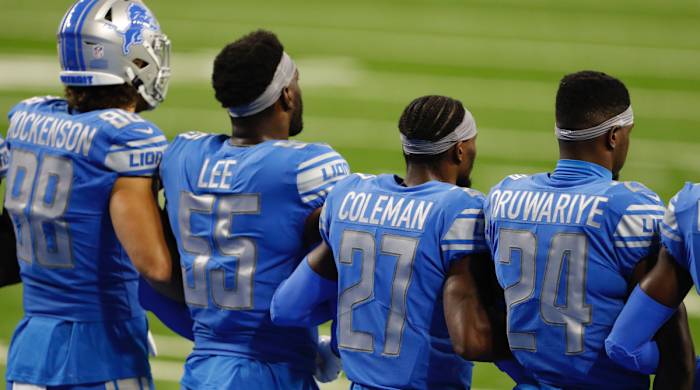 Detroit Lions players stand arm in arm